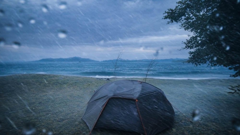 Motorcycle tent pitched beside the coast during heavy wind and rain in Ehime, Japan
