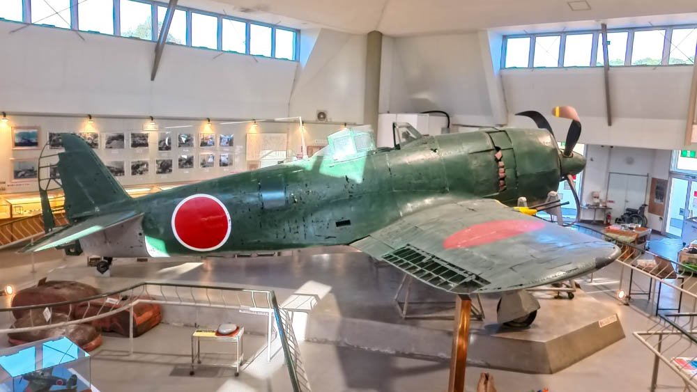 Historic Japanese military aircraft displayed inside a museum in Ehime
