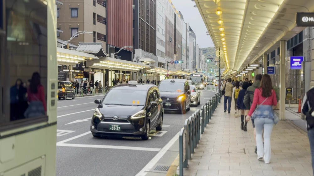 Traffic and pedestrians on a busy street in central Kyoto, Japan