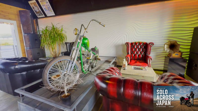 Custom chopper displayed among leather chairs inside a lakeside bar in Shiga