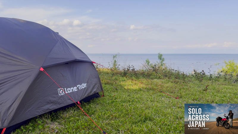 Motorcycle camping tent pitched on the grass beside Lake Biwa in Shiga